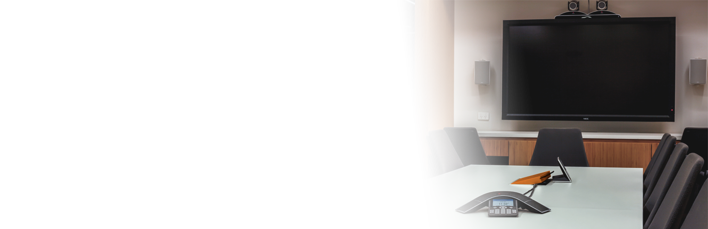 Modern board room with table, chairs, communication equipment with a TV on the wall