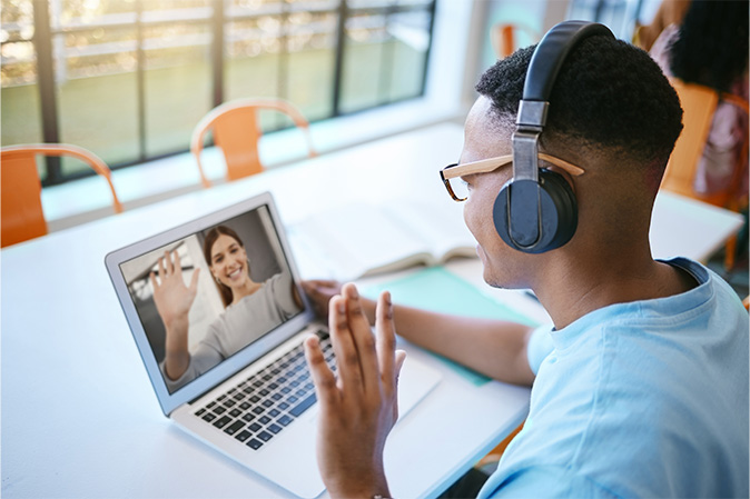 Video call, webinar and male student or employee waving for conference meeting on laptop, headphone and computer for communication. Remote black man on online zoom for education or chatting to friend.